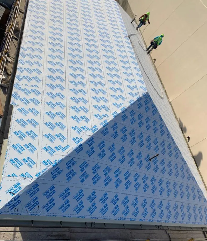 Professional roofers installing underlayment on a metal roof in Claymont